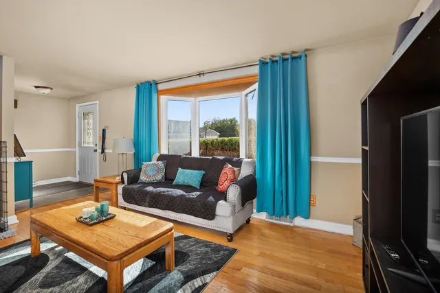 a living room with furniture a flat screen tv and a table