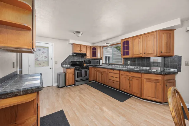 a kitchen with stainless steel appliances granite countertop a stove a sink dishwasher and a refrigerator