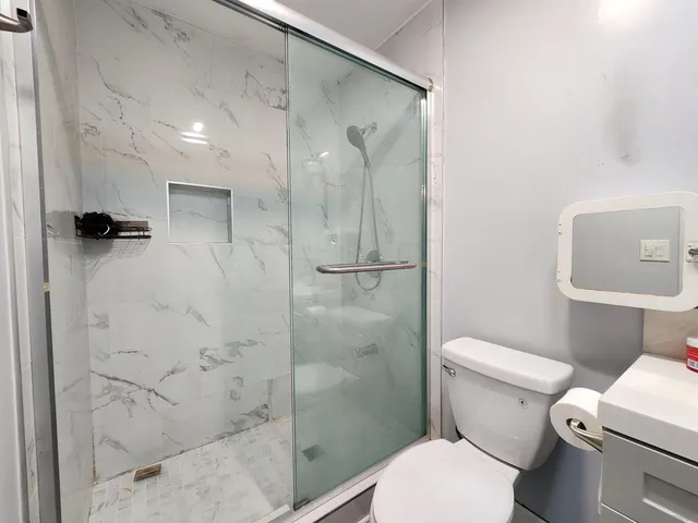 a bathroom with a toilet and a shower