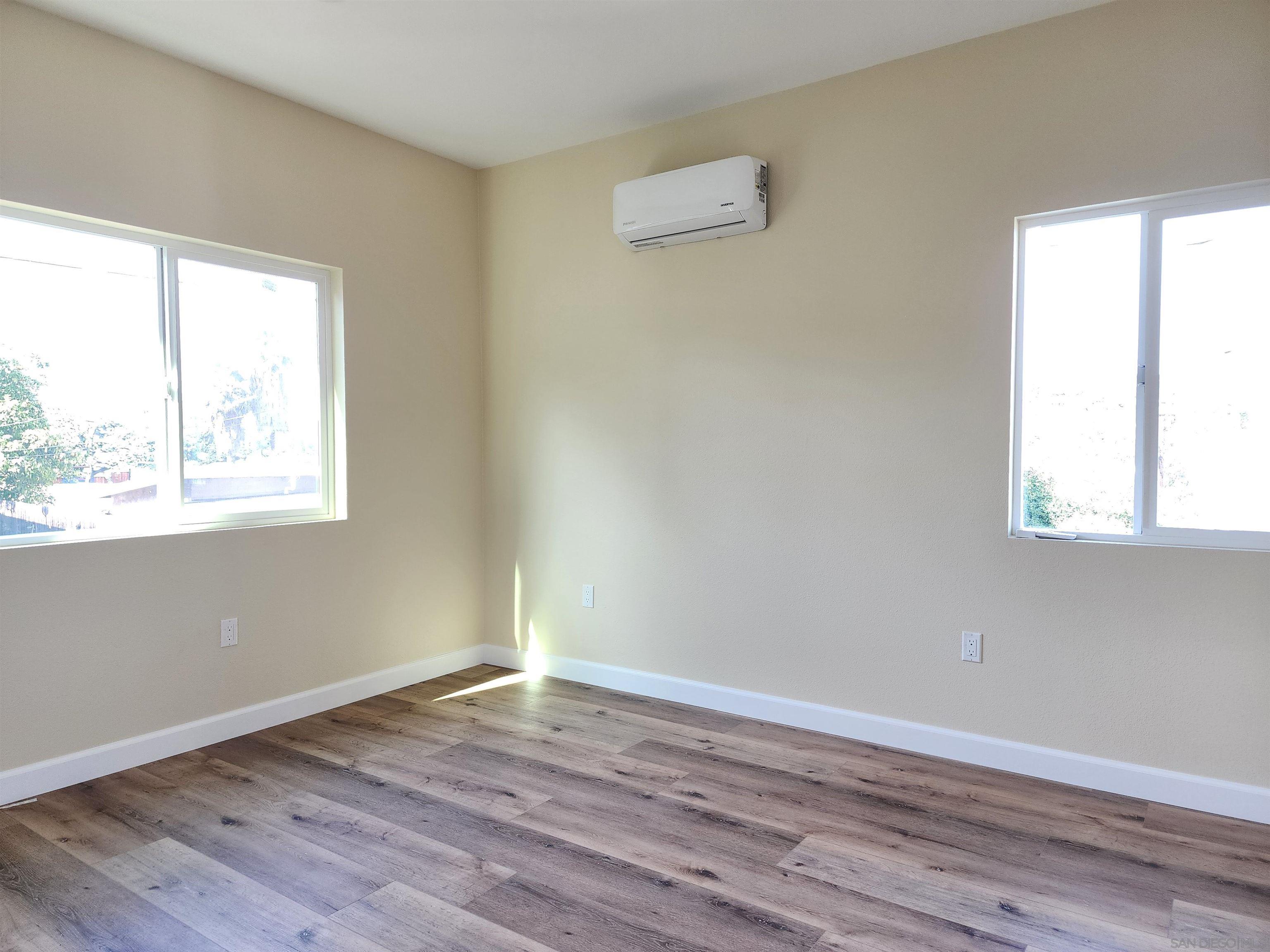 0 4024-4026 College Avenue San Diego, CA 92115 - Photo 19 of 20 an empty room with wooden floor and windows