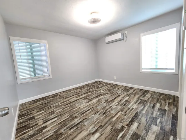 a view of a room with wooden floor and windows