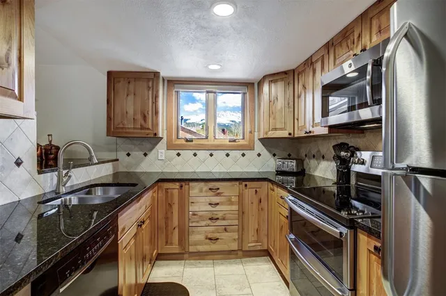 a kitchen with stainless steel appliances a sink stove and cabinets