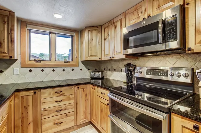 a kitchen with stainless steel appliances a stove microwave and cabinets