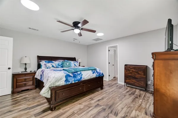 a bedroom with a bed and wooden floor
