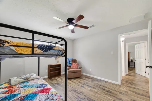 a bedroom with a bed and wooden floor