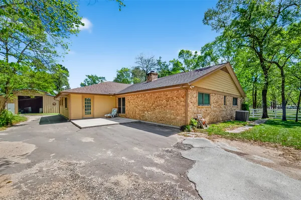 a view of a house with a yard and large tree