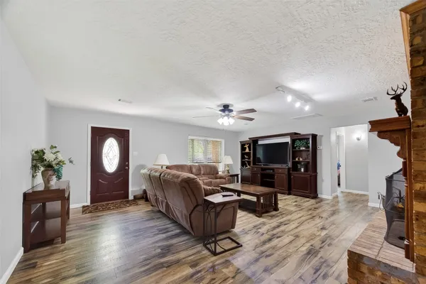 a living room with furniture a flat screen tv and wooden floor