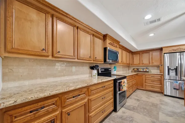 a kitchen with granite countertop stainless steel appliances and cabinets