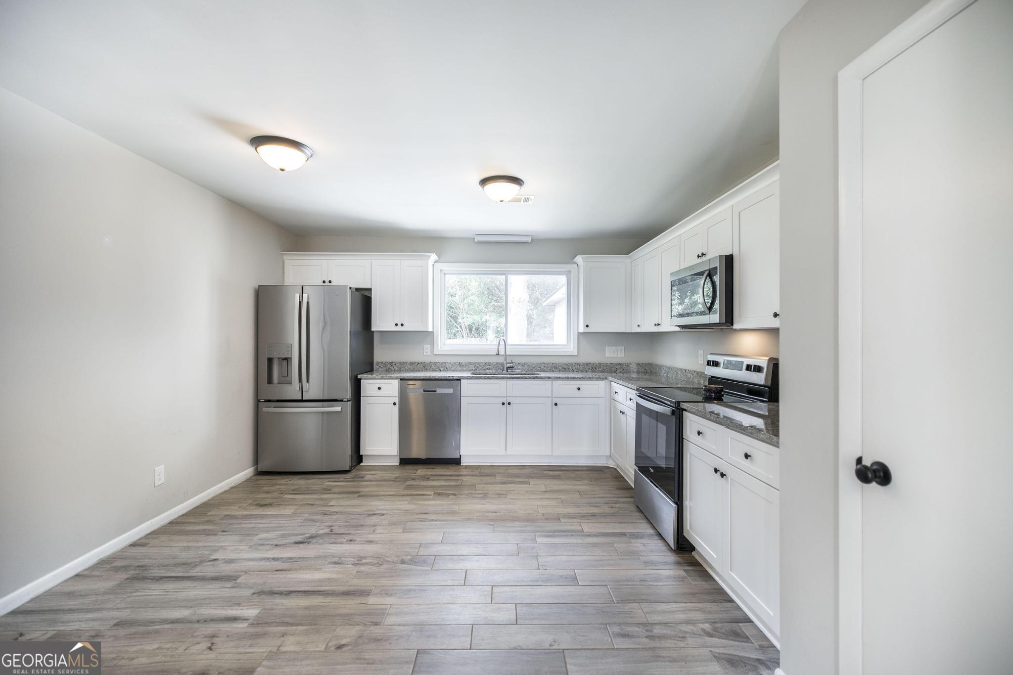 221 Gilchrist Drive Warner Robins, GA 31093 - Photo 11 of 33 a large kitchen with stainless steel appliances a refrigerator and a stove top oven