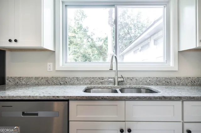 a kitchen with granite countertop a sink and a window
