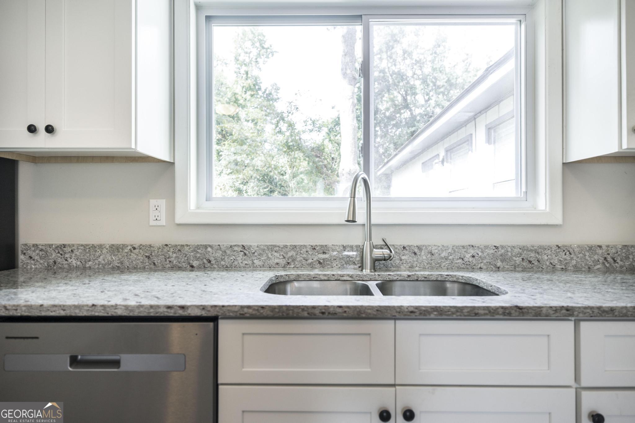 221 Gilchrist Drive Warner Robins, GA 31093 - Photo 13 of 33 a kitchen with granite countertop a sink and a window
