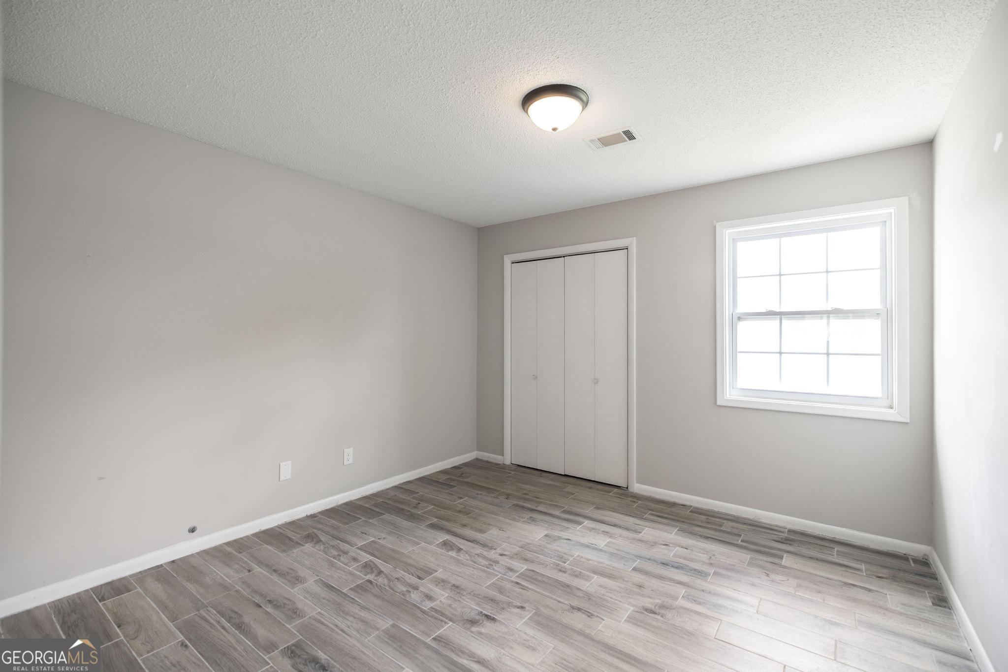 221 Gilchrist Drive Warner Robins, GA 31093 - Photo 19 of 33 an empty room with wooden floor and windows
