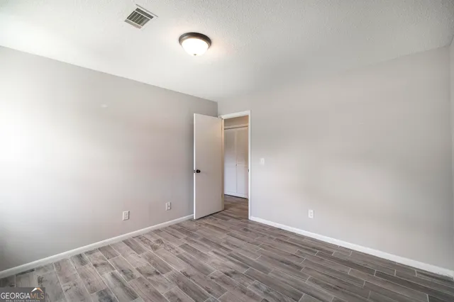a view of an empty room with wooden floor