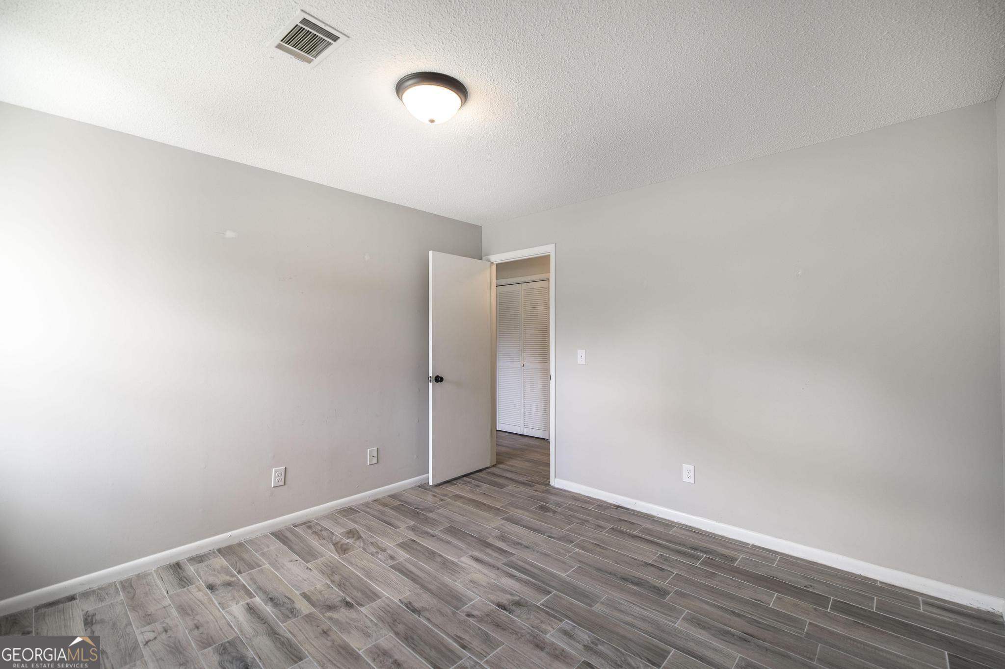 221 Gilchrist Drive Warner Robins, GA 31093 - Photo 20 of 33 a view of an empty room with wooden floor