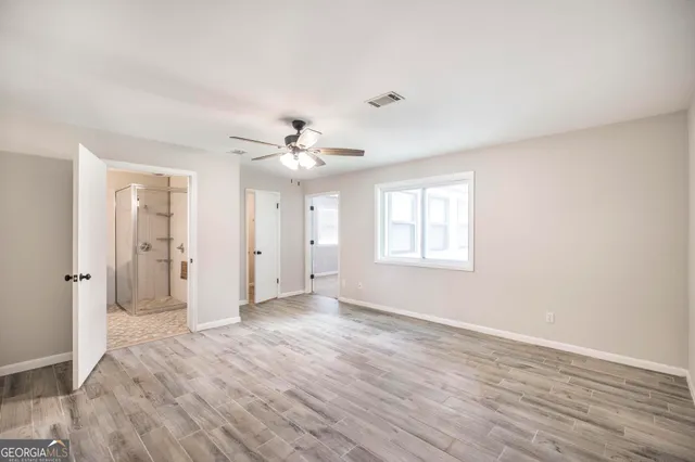 a view of an empty room with wooden floor