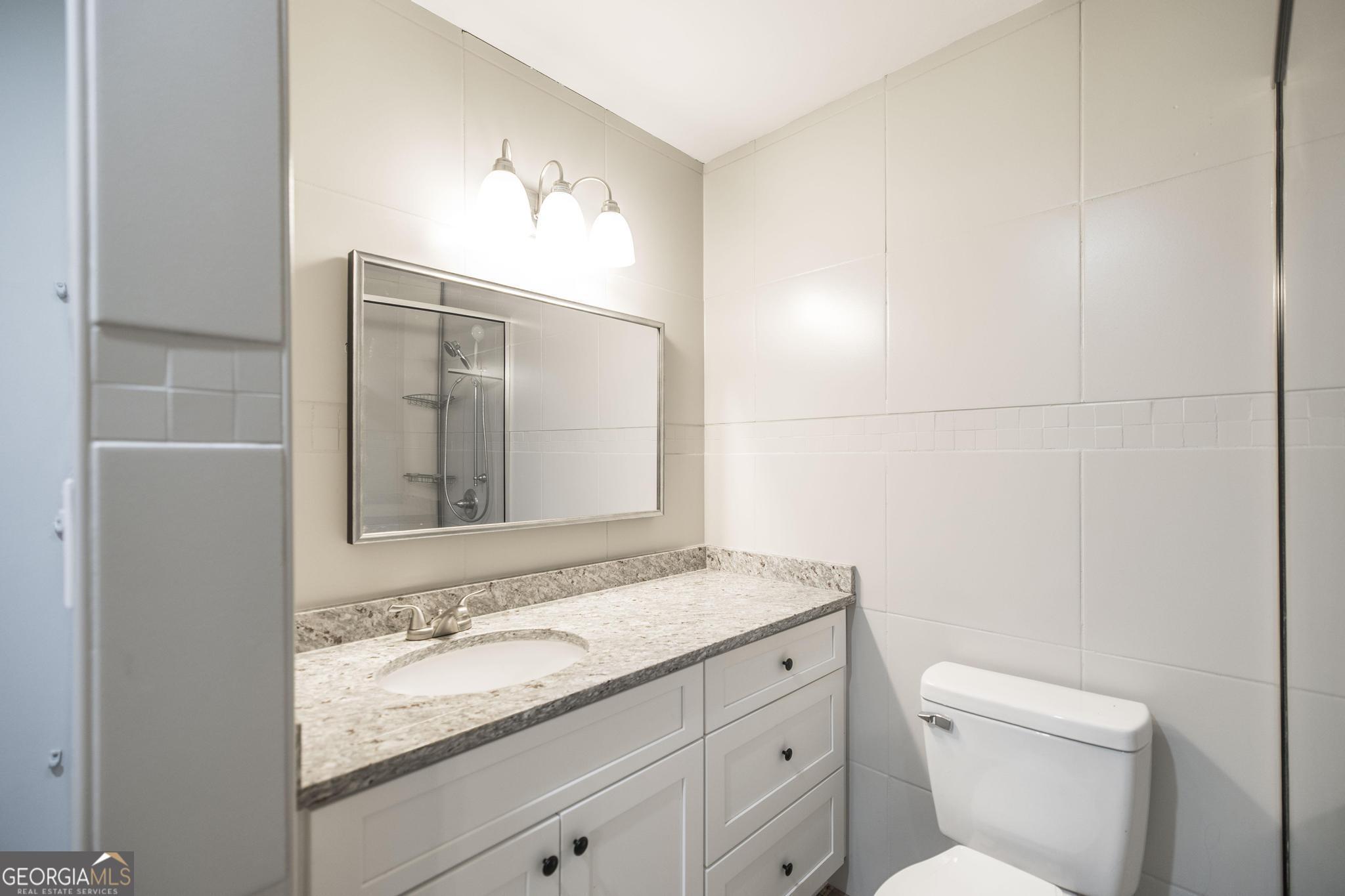 221 Gilchrist Drive Warner Robins, GA 31093 - Photo 24 of 33 a bathroom with a granite countertop sink and a mirror