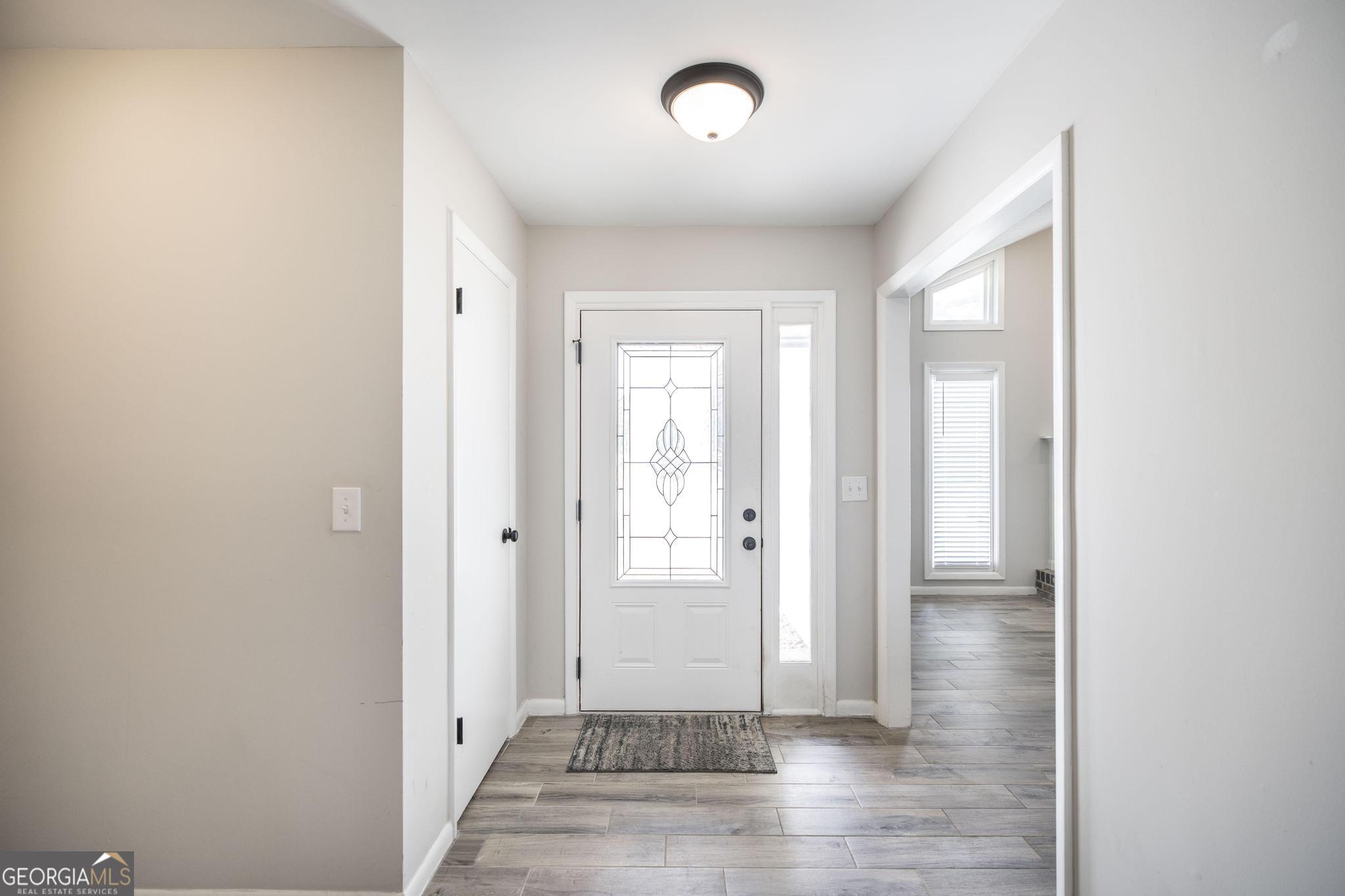 221 Gilchrist Drive Warner Robins, GA 31093 - Photo 5 of 33 a view of a hallway with wooden floor and a bathroom