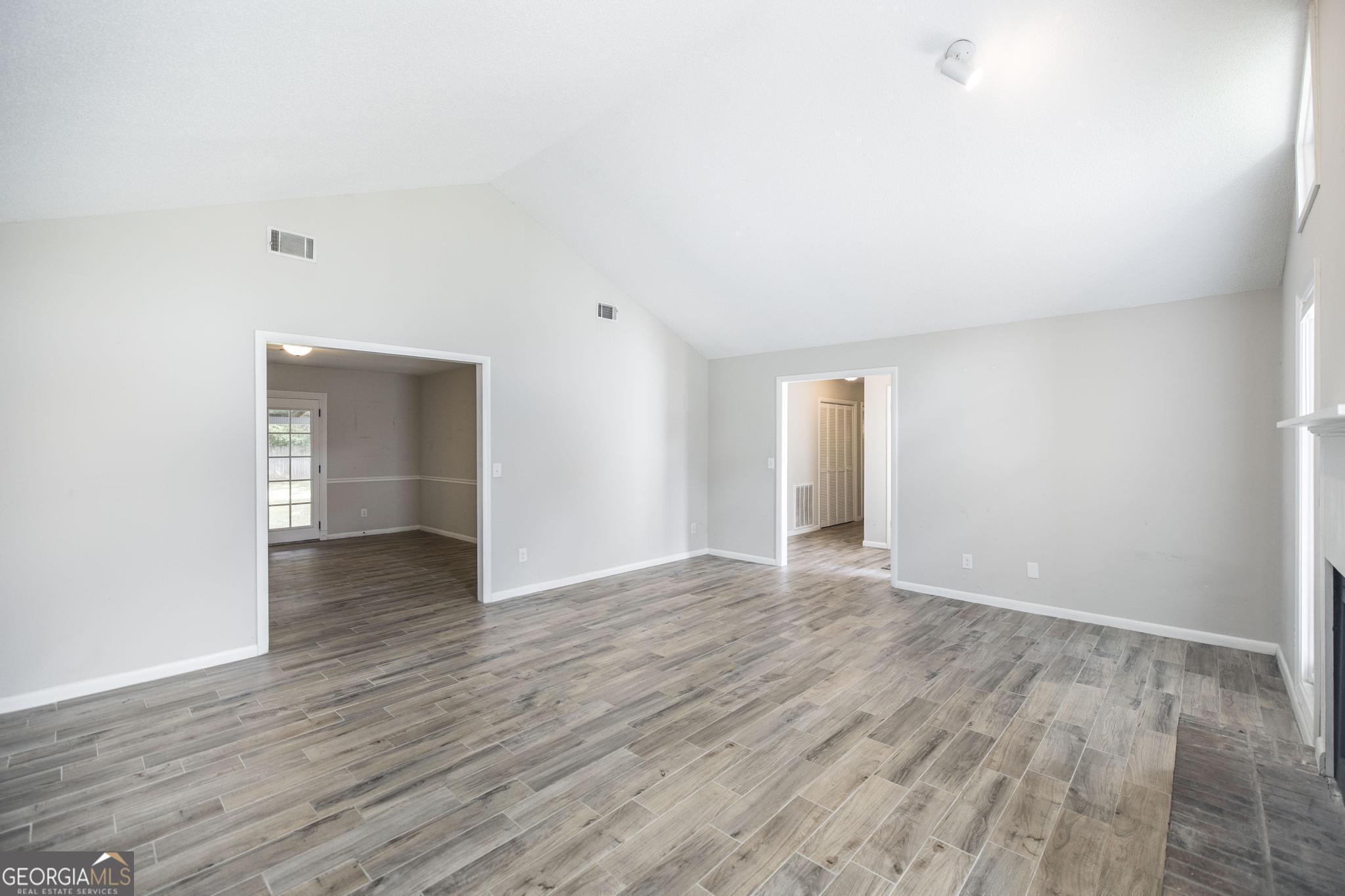 221 Gilchrist Drive Warner Robins, GA 31093 - Photo 7 of 33 a view of an empty room with wooden floor and a window
