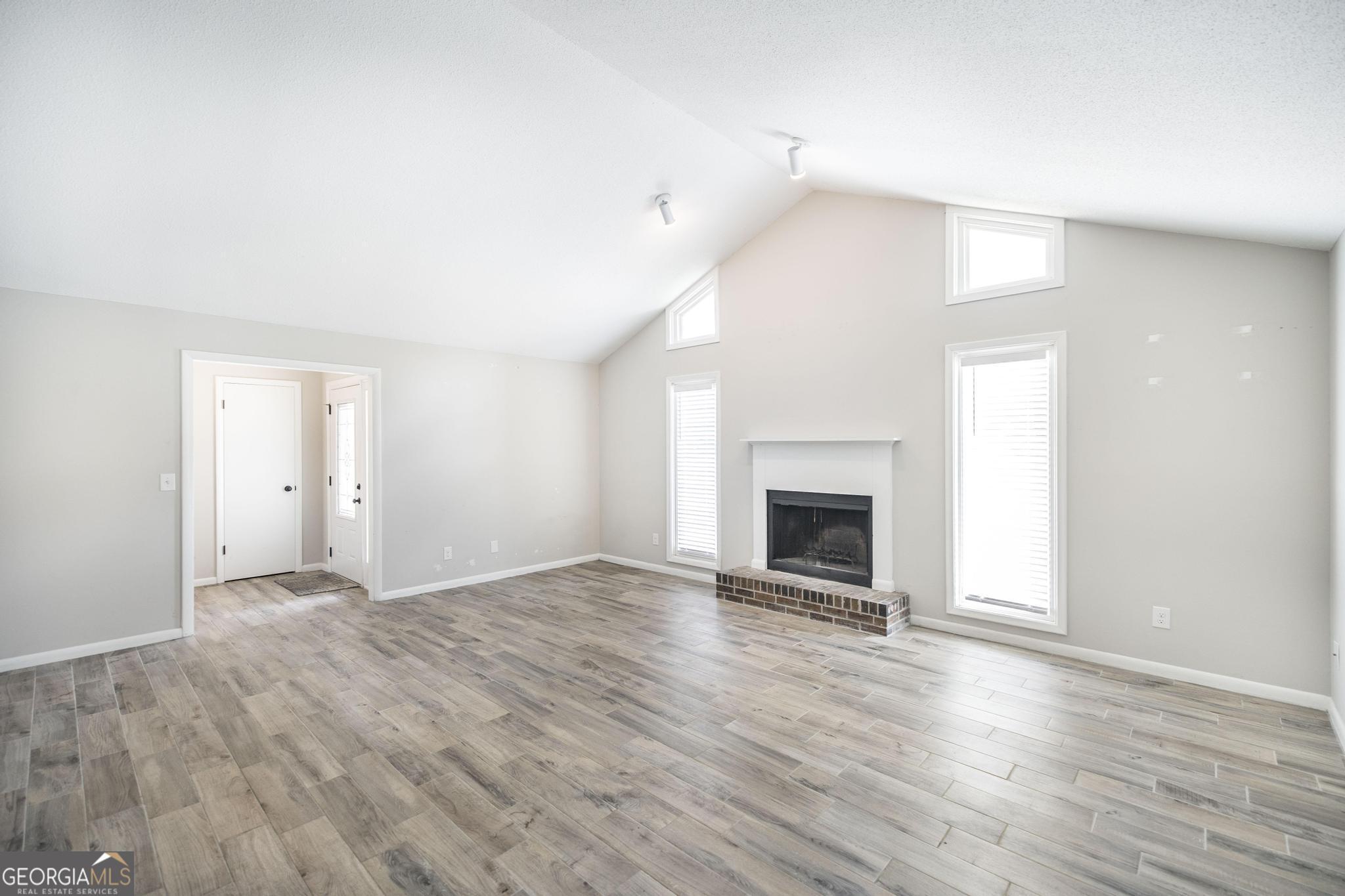 221 Gilchrist Drive Warner Robins, GA 31093 - Photo 8 of 33 a view of an empty room with wooden floor fireplace and a window