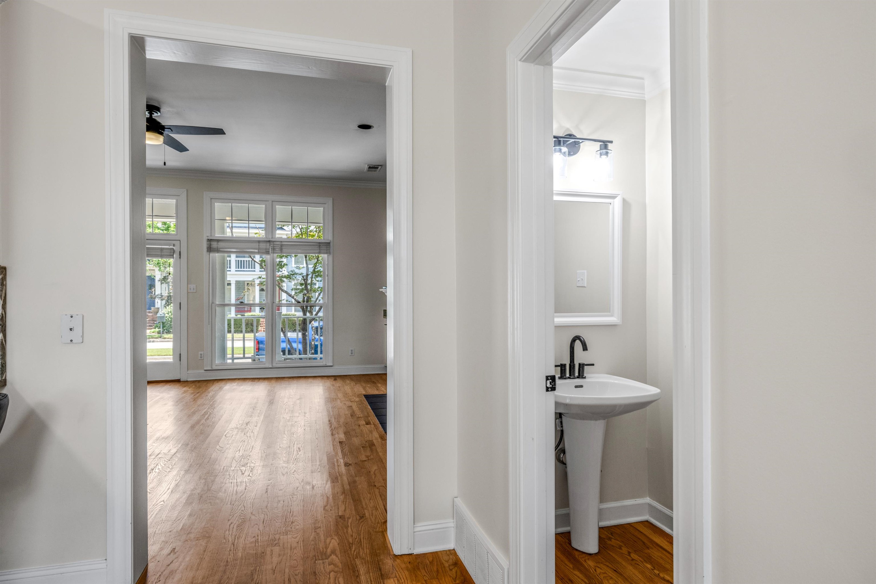 921 Harbor View Drive Memphis, TN 38103 - Photo 19 of 33 Pedestal sink with matte black faucet, wall-mounted mirror, and vanity light fixture