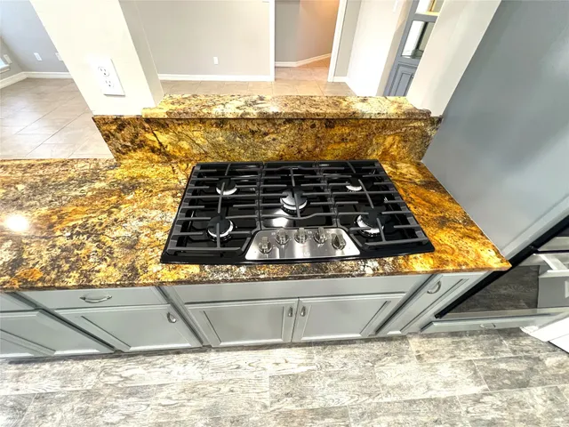 a kitchen with granite countertop white cabinets and black appliances