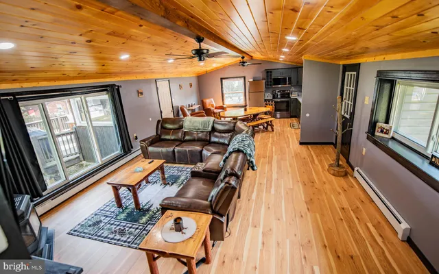 a living room with furniture stove and wooden floor