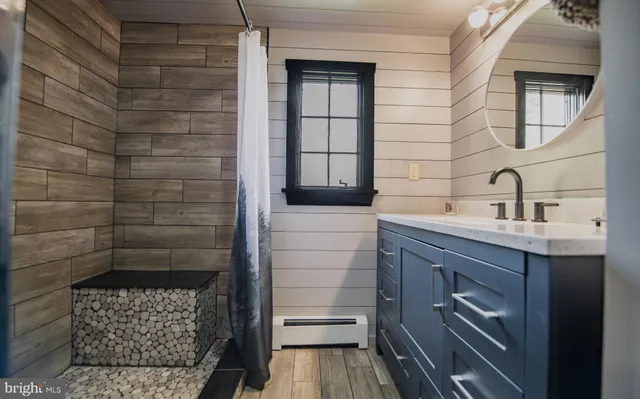 a bathroom with a sink a toilet and shower