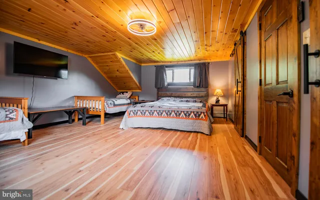a view of a hall with wooden floor and flat screen tv
