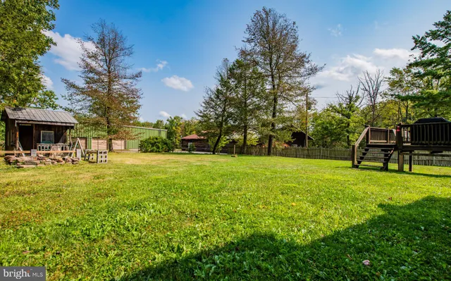 a view of a house with backyard and a tree