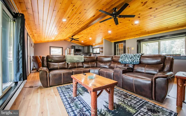a view of a patio with couches chairs and wooden floor