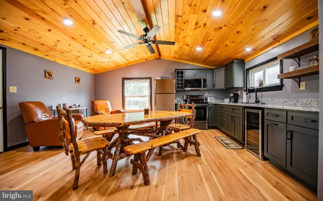a dining hall with stainless steel appliances granite countertop a stove and cabinets with wooden floor