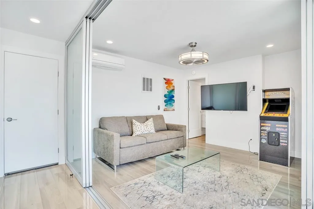 742 Neptune Avenue Encinitas, CA 92024 - Photo 18 of 25 a living room with furniture a flat screen tv and kitchen view