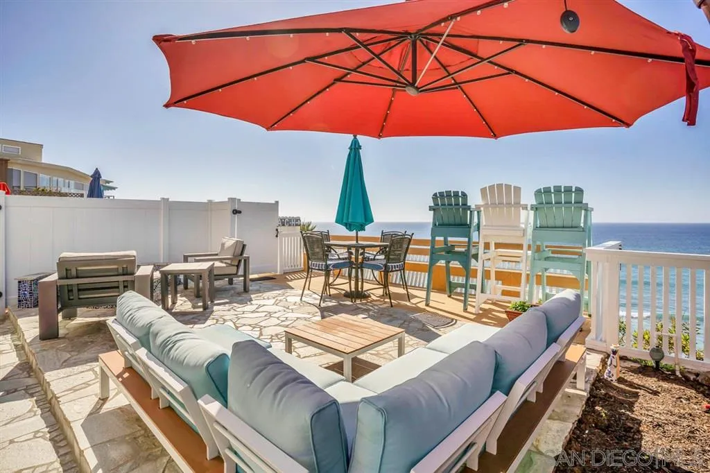 742 Neptune Avenue Encinitas, CA 92024 - Photo 21 of 25 a view of a patio with couches chairs under an umbrella
