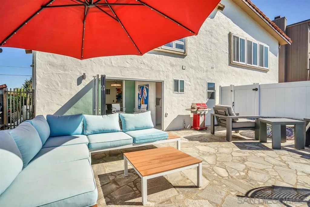 742 Neptune Avenue Encinitas, CA 92024 - Photo 22 of 25 a view of a patio with a dining table and chairs under an umbrella