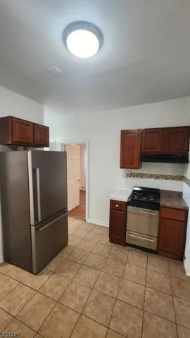 a kitchen with stainless steel appliances granite countertop a refrigerator and a stove