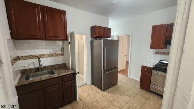 a kitchen with stainless steel appliances granite countertop a refrigerator and a stove