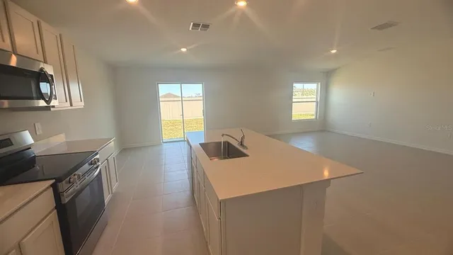 a kitchen with a sink a stove and a window