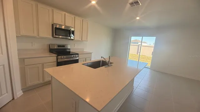 a kitchen with stainless steel appliances a microwave a sink and a refrigerator