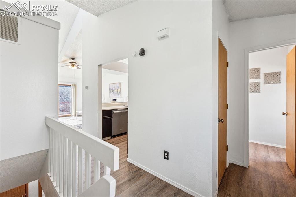 6447 Jonathan Court Colorado Springs, CO 80918 - Photo 9 of 16 a view of a hallway with wooden floor and dining room