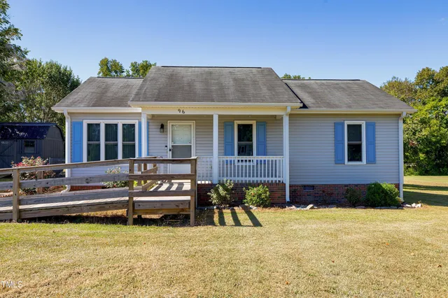 a view of a house with pool and chairs