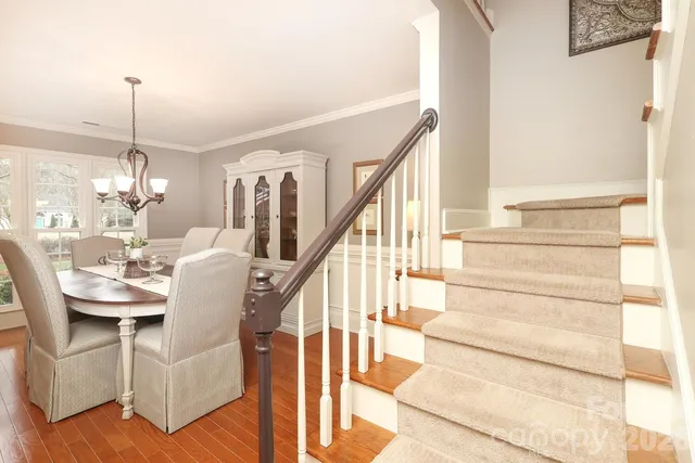 a dining room with furniture a chandelier and wooden floor