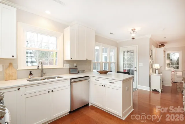 a kitchen with cabinets stainless steel appliances a sink and a window