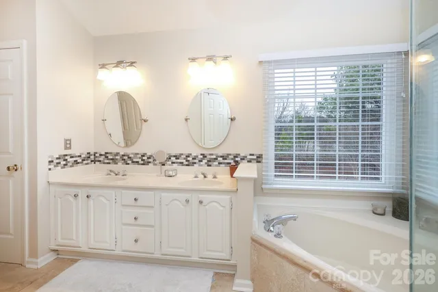 a bathroom with a granite countertop shower a sink and a window