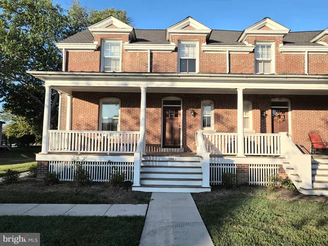 a view of a brick house with wooden fence