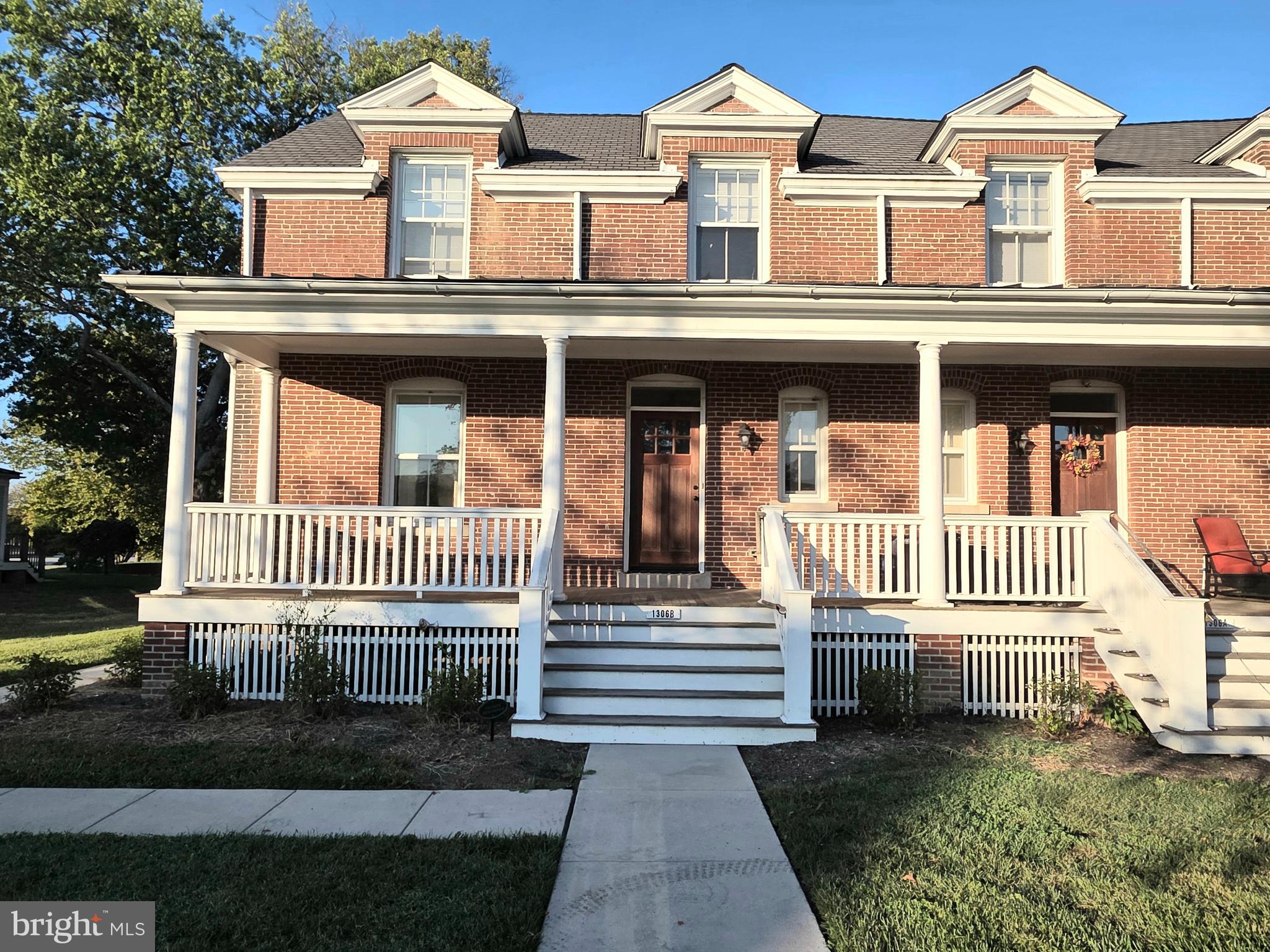 a view of a brick house with wooden fence
