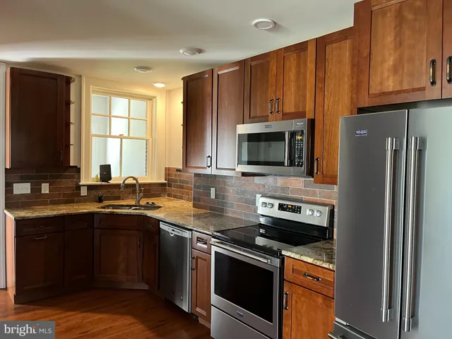 a kitchen with stainless steel appliances a stove a sink and a microwave