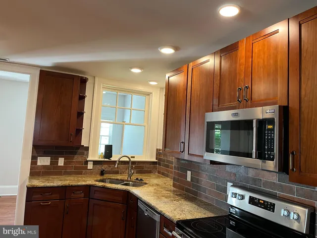 a kitchen with a sink stove and microwave