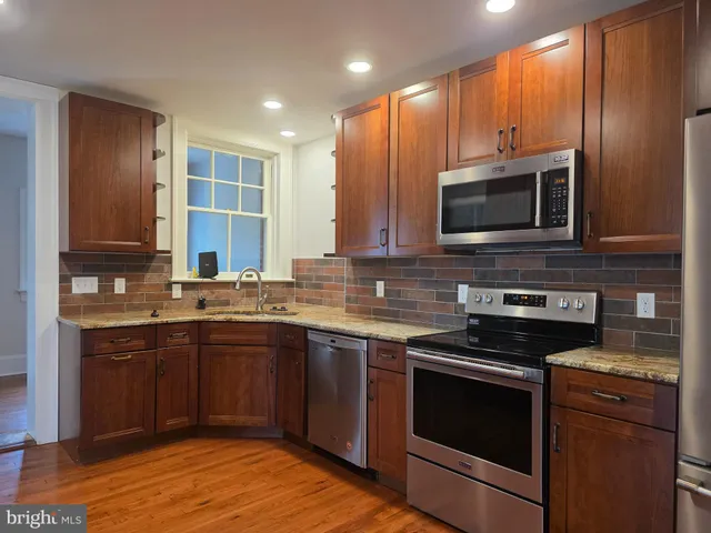 a kitchen with stainless steel appliances a stove sink microwave and cabinets