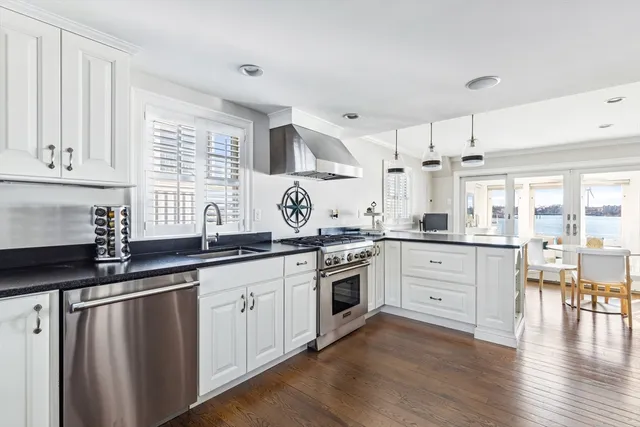 a kitchen with granite countertop white cabinets and white appliances
