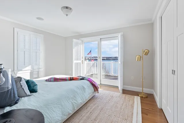 a bedroom with a balcony a bed and a window